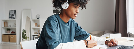 side-view-portrait-africanamerican-teenage-boy-studying-home-college-dorm-using-lapt.jpg